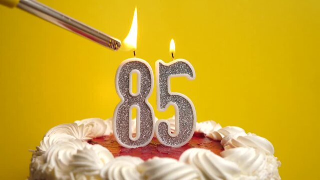 A candle in the form of the number 85, inserted into the holiday cake, is lit. Celebrating a birthday or a landmark event. The climax of the celebration.