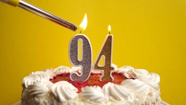 A candle in the form of the number 94, inserted into the holiday cake, is lit. Celebrating a birthday or a landmark event. The climax of the celebration.