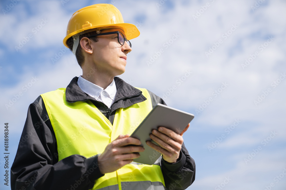 Poster engineer with digital tablet on a background of blue sky