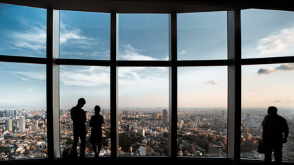 Three People Standing in Front of the Curved Glass of Tokyo Roppongi Hills