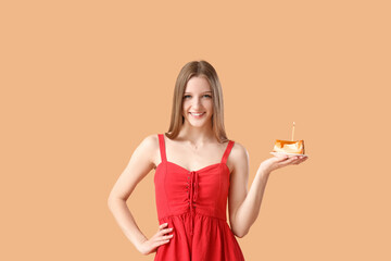 Beautiful young woman with sweet birthday cake on beige background