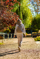 Fototapeta premium Beautiful woman walking in city park 