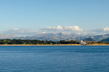 Sunny spanish coastline with calm sea. Dramatic mountains in the background.