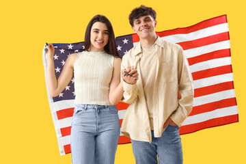 Obraz premium Young couple with USA flag on yellow background