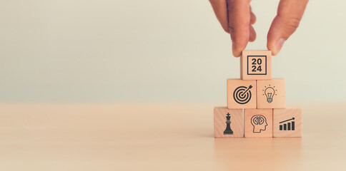 Business goal, plan, action in 2024. Wooden cubes with icon business strategies, action plan, goal, increase sale, process, game plan. Business strategies and achieving goals. Sustainable development.