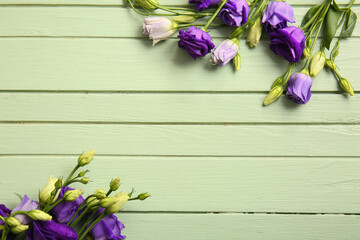 Composition with beautiful eustoma flowers on color wooden background