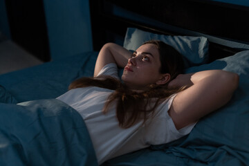 Fototapeta na wymiar Sleep disorder, insomnia. Young woman lying on the bed awake at late night. Can not sleep