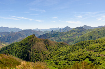 Fototapeta na wymiar Mountain peaks in Spain national park Picos de Europa. Beautiful green hill tops full of trees and nature.
