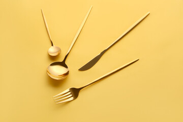 Stylish cutlery on yellow background