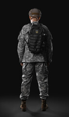 Ukrainian soldier with backpack on dark background, back view