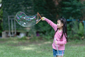Asian girl playing with a bubble machine.