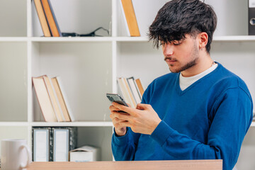 young male student with mobile phone or smartphone