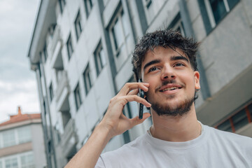 young man on the street talking on mobile phone or smartphone