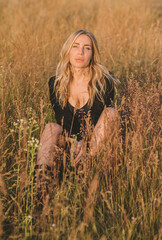 Freedom spirit. American girl at field. Young beautiful woman in Boho black fringe jacket and...