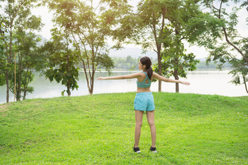 A sporty woman in sportswear exercises at the garden in front of her home. Girl prepare herself for running.