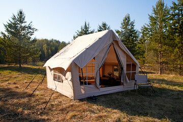 Camping tent under the pine forest. Inflatable tent © Sergey Kalsin