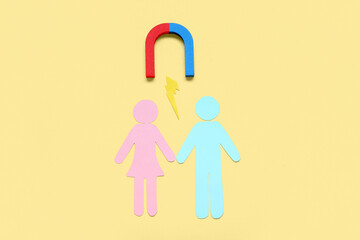 Couple made of paper with magnet and lightning on pale yellow background