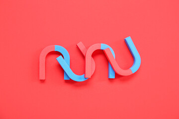 Horseshoe shaped magnets on red background