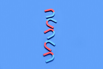 Horseshoe shaped magnets on blue background