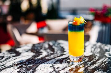 Fresh cold mango cocktail, mango juice smoothie in glass outdoors