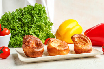 Plate with tasty Yorkshire pudding on light background