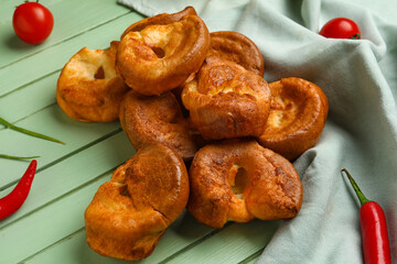 Tasty Yorkshire pudding on green wooden background