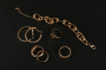 Fototapeta na wymiar Beautiful chain bracelet and rings on black background