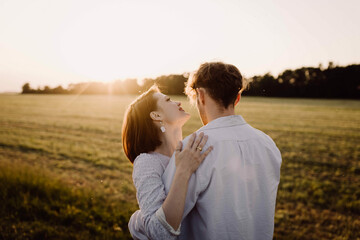 couple in love in a field at sunset on a date in summer. Wedding engagement of a young couple.