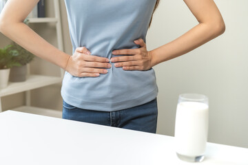 Pain, suffering asian young woman having a stomachache, abdominal pain or digestive, hand in...