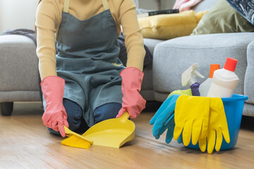 Household hygiene clean up, housekeeper woman hand in pink rubber protective gloves with yellow broom and dustpan sweeping remove dust on floor at home, equipment or tool for cleaning, cleaner people.