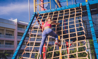 Athletic young woman working out and climbing at the training camp.