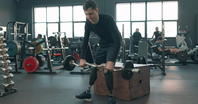 active ambitious disabled man working out with a barbell, motivation weightlifting bodybuilding free time spare time lifestyle hobby interests workout routine. endurance, willpower