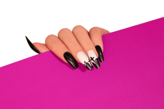Halloween nail design black white color with cross. Female hand with autumn manicure hold pink paper on transparent background. Halloween concept.