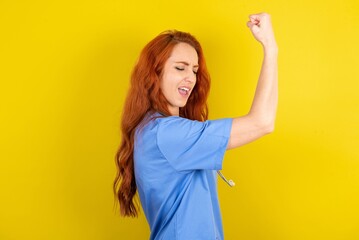 Profile photo of redhead doctors woman wearing blue uniform over yellow wall supporting soccer team...