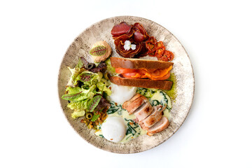 Poached egg with sun-dried tomatoes, bacon roll, prosciutto, and lettuce