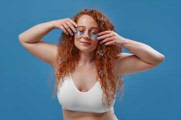 Redhead girl with freckles on a blue background