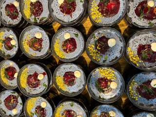 Prepared many small dark plates beets with nuts and mayonnaise garnished with herbs. Vegetarian,  healthy lifestyle.