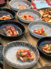 Fried baguette with red salmon fish and vegetables, on small plates, small tartlet, buffet food for vegetarian people, healthy lifestyle.