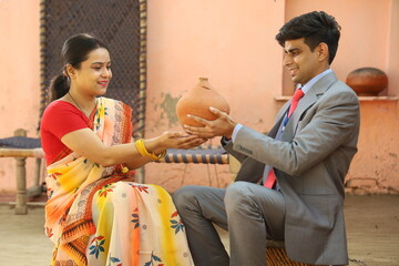 Happy Indian woman in saree taking loan from the banker. Holding piggy bank in hand.