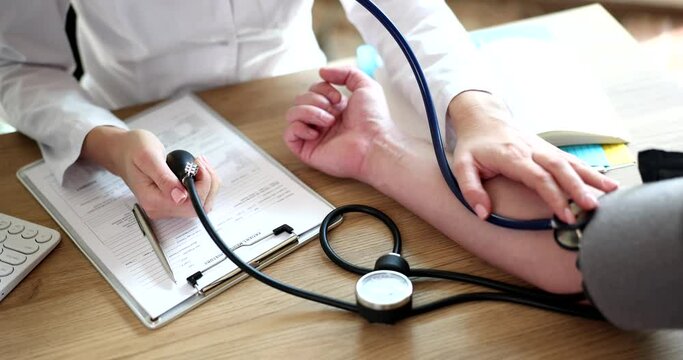 Therapist cardiologist using tonometer checks patient blood pressure. Arterial hypertension and syndrome of increased clinical arterial pressure
