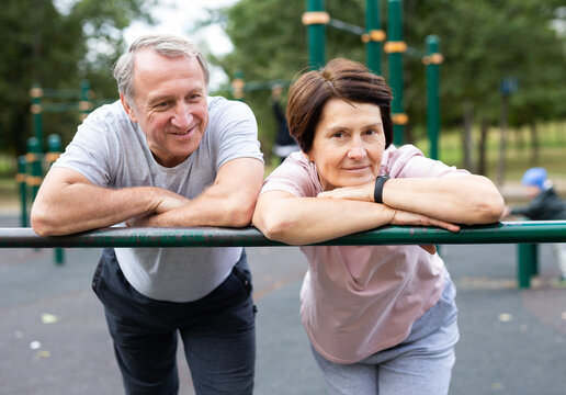 Elderly man and woman posing in open-air sports bars complex