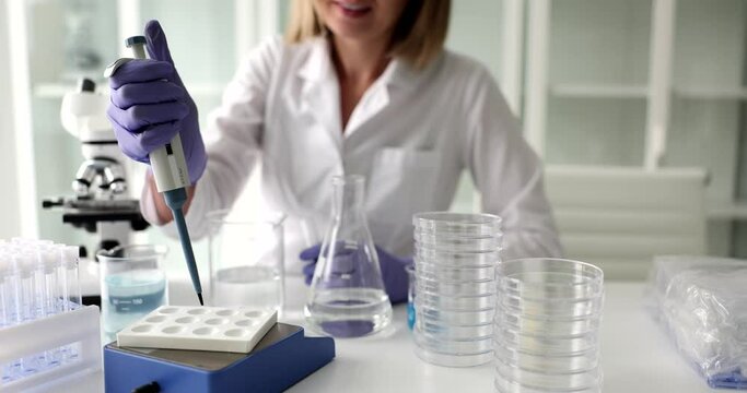 Scientist analyzes te liquid with pipette to extract toxins from samples. Testing water quality in laboratory