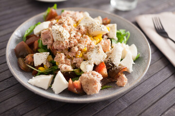 Fish salad with canned tuna and corn, tomatoes and arugula