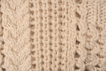 A fragment of beige knitted fabric, knitted from white sheep wool.