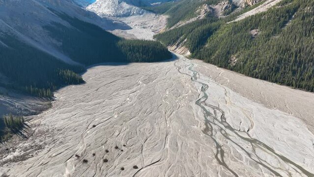 Drone view of the river and forest in the glacier valley. View of the moraines. Landscape from the air.  River on a moraine. Landscape from drone. Abstract view for wallpaper. 