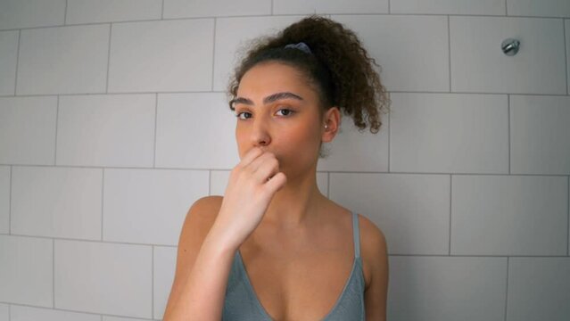 sexy girl in blue bra holding toothbrush and looking at camera, close up slow motion, student performing water procedures