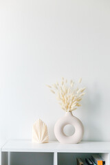 Dried hare's tail grass.Aesthetic cozy home decoration. Scandinavian minimal interior style. Hygge scene with candles. Creative composition of living room interior with copy space. Stylish round vase.