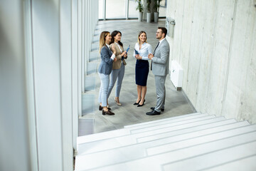 Young startup team have a discussion by stairs in the office corridor