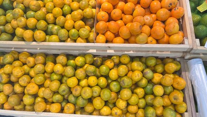 Green oranges and orange tangerines in the market