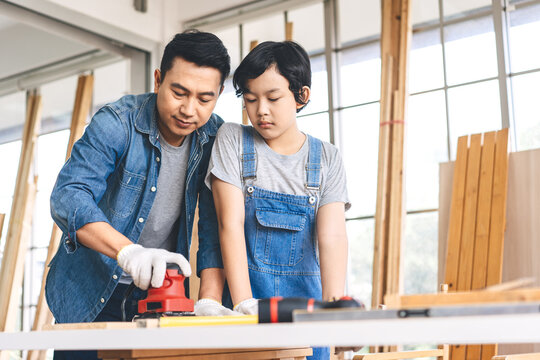 Southeast asian family father and son diy or repair for crafts skill at home workshop
